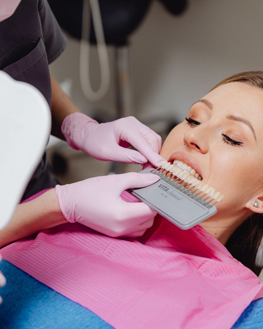 Dentist matching a composite filling shade to the patient's natural tooth colour at The Port Dental Clinic Calgary NE