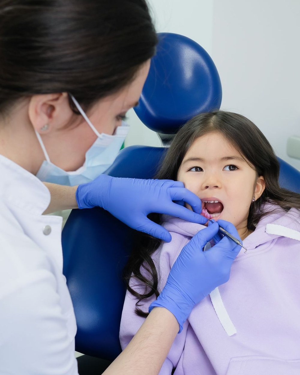 Dentist checking a child's back teeth before placing sealants at The Port Dental Clinic Calgary NE