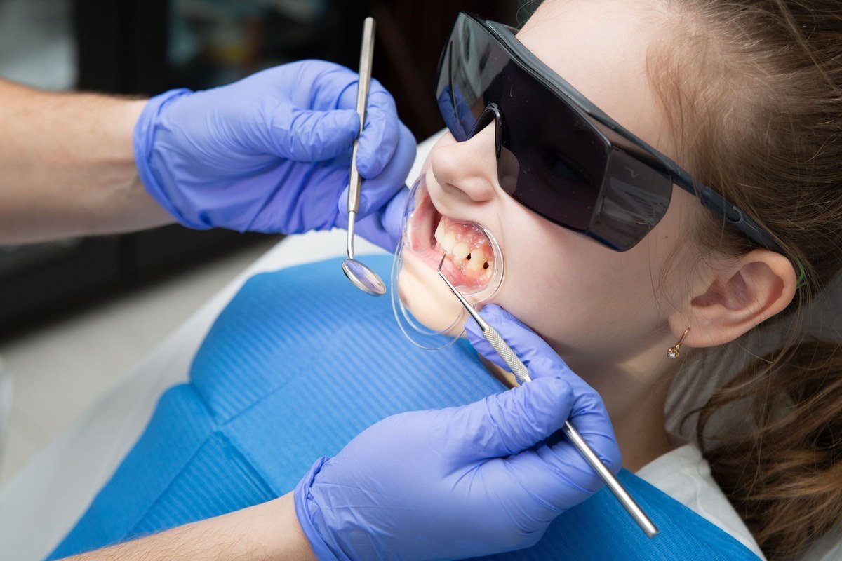 Child receiving preventive dental treatment with protective eyewear at The Port Dental Clinic in Calgary NE