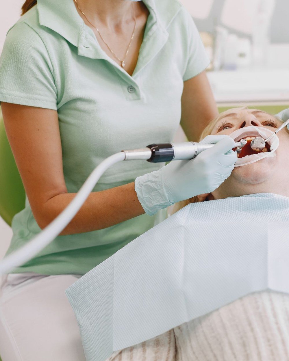 Dental hygienist performing a scale and polish during a cleaning appointment at The Port Dental Clinic Calgary NE