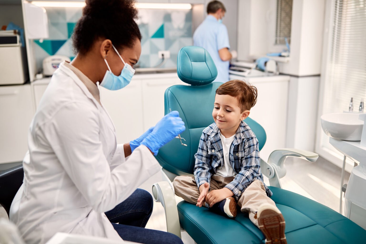little-boy-talking-to-african-american-female-dentist