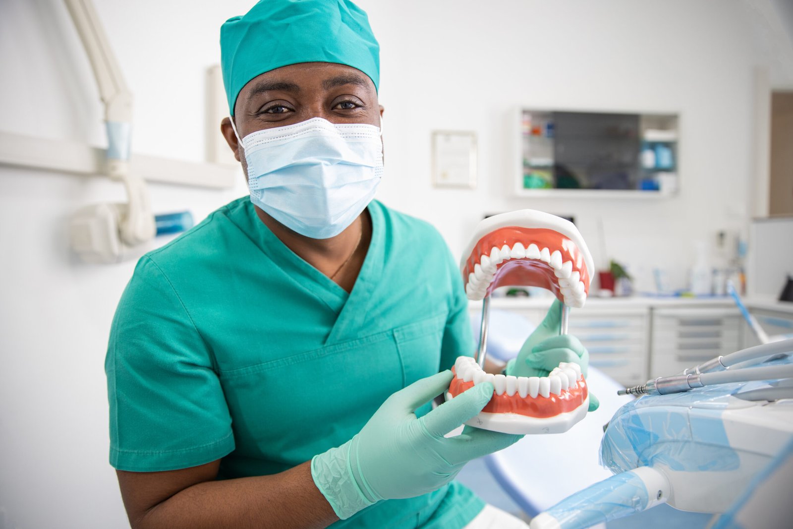 An african dentist holding a dentition teeth model in his hand, dental health concept.